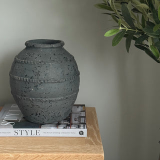 black stone vase style with book on table 