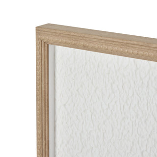 A section of wall art featuring a white quill feather design with a beige border and a visible wooden frame.