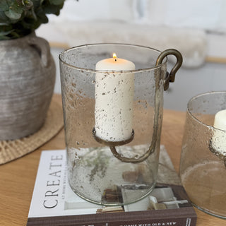 Decorative candle holders with candles on a book titled 'CREATE' in a home setting.