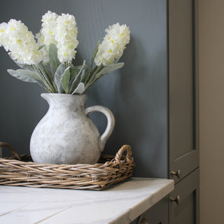 Grey stone Jug in basket tray in blue kitchen 