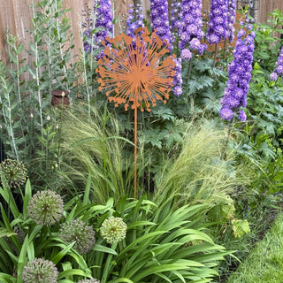 Garden scene with lavender, green foliage, and a decorative metal flower sculpture.