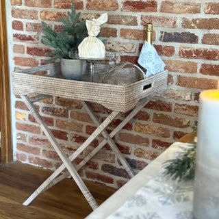 Decorative tray with a plant and candles on a brick wall background