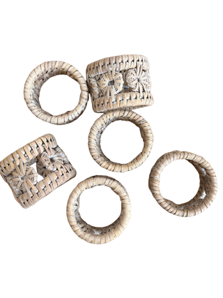 Set of six woven napkin rings on a white background