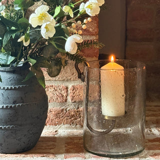 Decorative wall light fixture with flowers against a brick wall