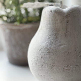 Close-up of a textured stone planter with another planter in the background.