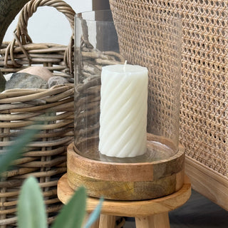 Candle holder with a candle on a wooden stool