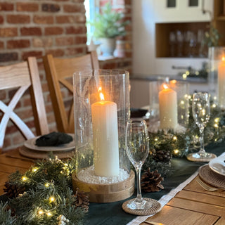 Dining table set with candles, glasses, and decorative elements in a home setting.
