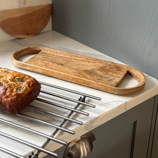 Wooden serving board on a kitchen counter with cake 