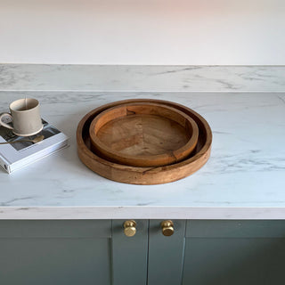 Wooden bowls on a marble surface with gray cabinets in the background