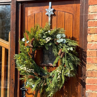 Christmas wreath on a wooden door with a snowflake decoration.