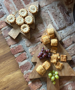 Wooden board with crackers and grapes on a brick wall background