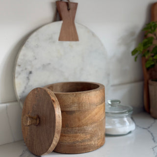 Wooden container with a lid on a marble surface